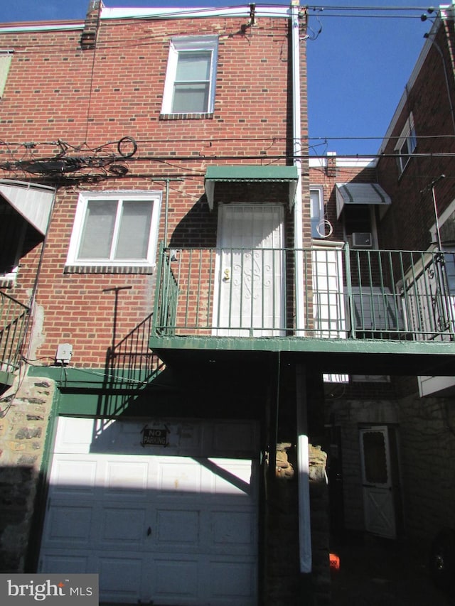 exterior space with a balcony and brick siding