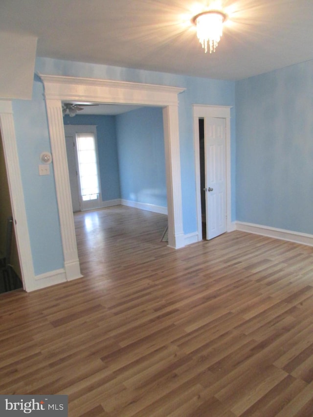 empty room with dark wood-type flooring and baseboards