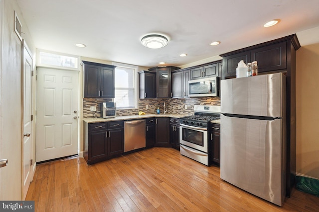 kitchen with decorative backsplash, light hardwood / wood-style flooring, and appliances with stainless steel finishes