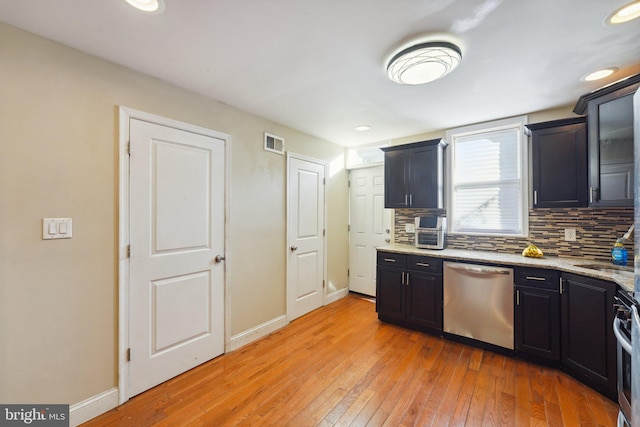 kitchen featuring light stone countertops, backsplash, stainless steel appliances, and light hardwood / wood-style flooring