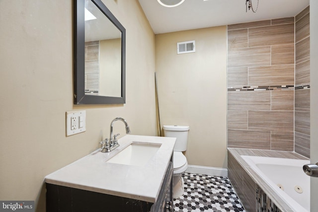 bathroom featuring vanity, toilet, and tiled tub