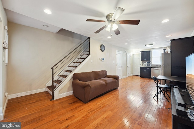 living room featuring hardwood / wood-style floors and ceiling fan