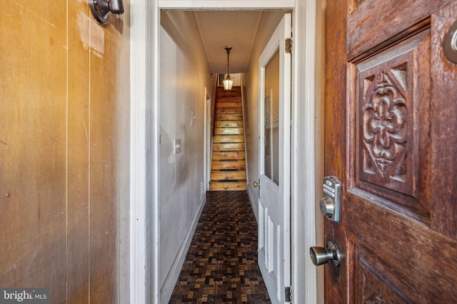 corridor with dark parquet floors and wood walls