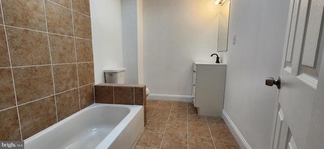 bathroom featuring tile patterned floors, a bathtub, vanity, and toilet