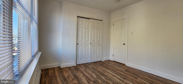 unfurnished bedroom featuring dark wood-type flooring and a closet