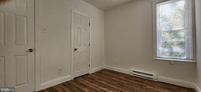 interior space with multiple windows, dark wood-type flooring, and a baseboard heating unit