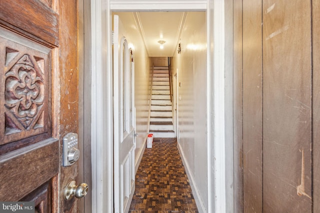 corridor with dark parquet floors and crown molding