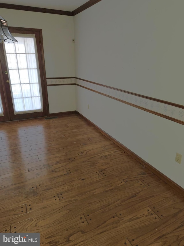 spare room with ornamental molding and dark hardwood / wood-style flooring