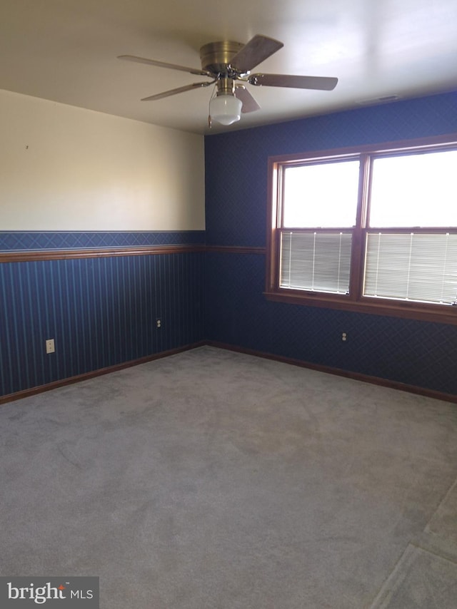 carpeted spare room with ceiling fan