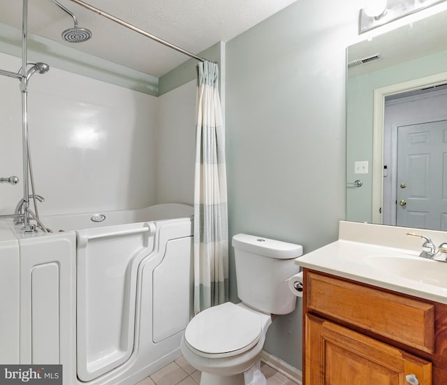 bathroom with tile patterned floors, vanity, a textured ceiling, and toilet