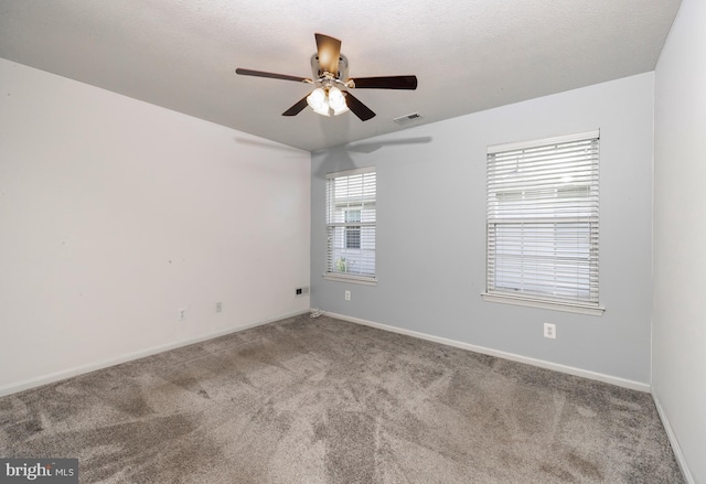 unfurnished room with a wealth of natural light, carpet floors, a textured ceiling, and ceiling fan