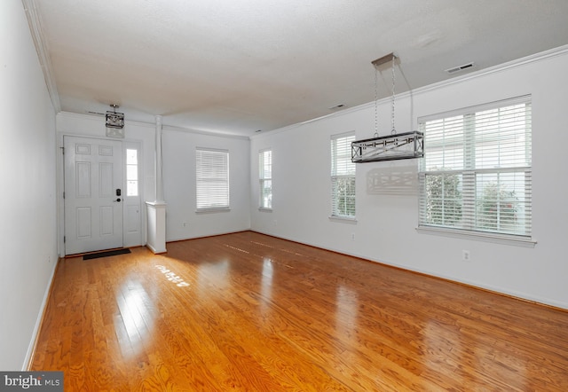 entryway featuring plenty of natural light, hardwood / wood-style floors, and ornamental molding