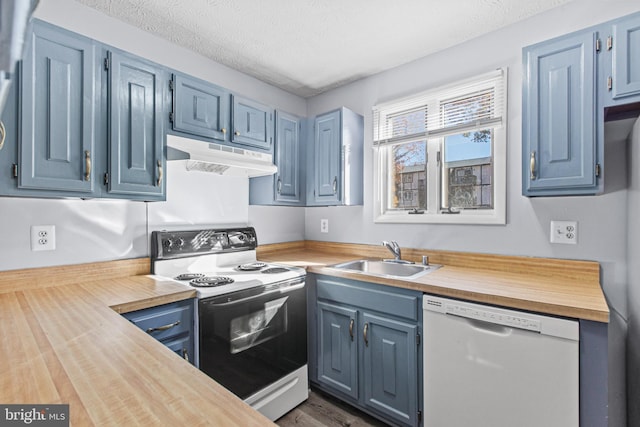 kitchen with a textured ceiling, butcher block counters, sink, and white appliances