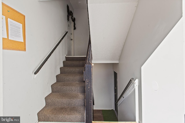 stairs featuring hardwood / wood-style floors