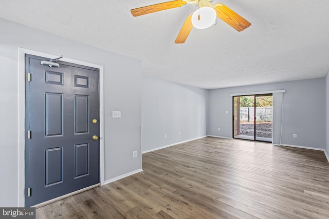 entryway with ceiling fan, wood-type flooring, and a textured ceiling