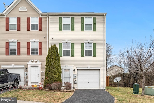 multi unit property with a front yard and a garage