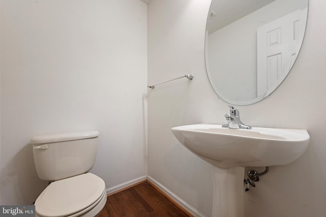 bathroom with toilet and hardwood / wood-style flooring