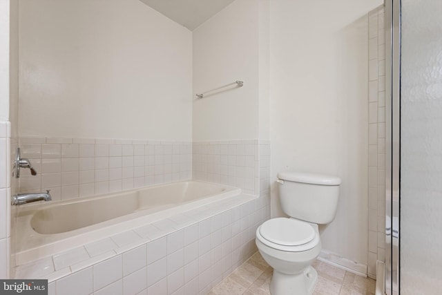 bathroom featuring toilet and tiled tub