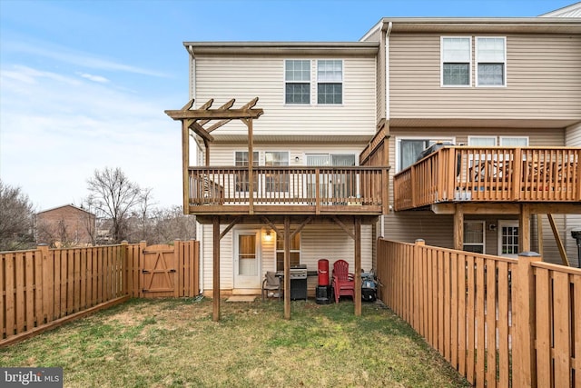 back of property with a pergola, a wooden deck, and a lawn