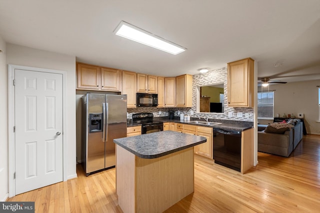 kitchen featuring sink, a center island, black appliances, and light hardwood / wood-style floors