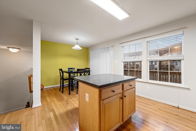 kitchen featuring pendant lighting, light hardwood / wood-style flooring, and a kitchen island