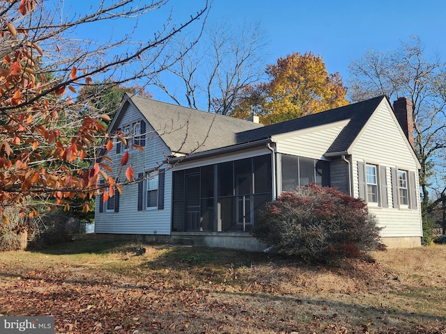 view of home's exterior featuring a sunroom and a yard