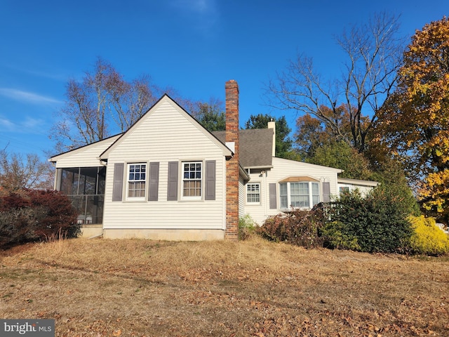 view of home's exterior featuring a lawn and a sunroom