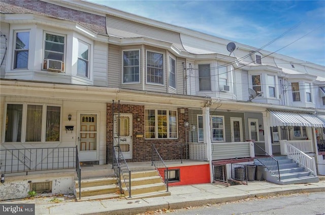 townhome / multi-family property featuring cooling unit and a porch