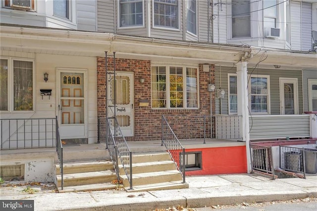 doorway to property with a porch and cooling unit