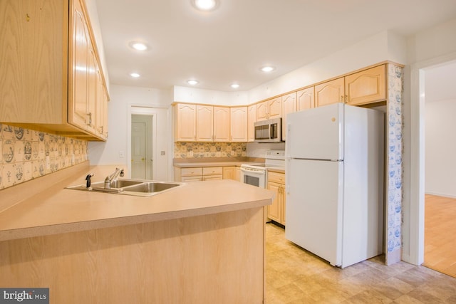 kitchen with kitchen peninsula, light brown cabinets, white appliances, and sink