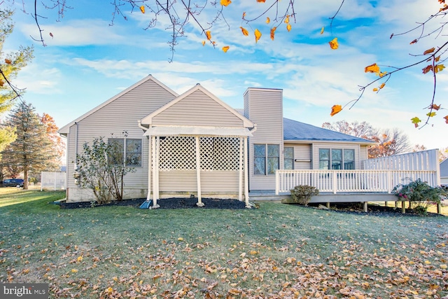 back of house featuring a deck and a yard