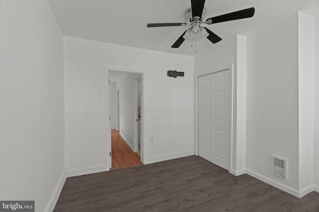 empty room featuring ceiling fan and dark hardwood / wood-style flooring