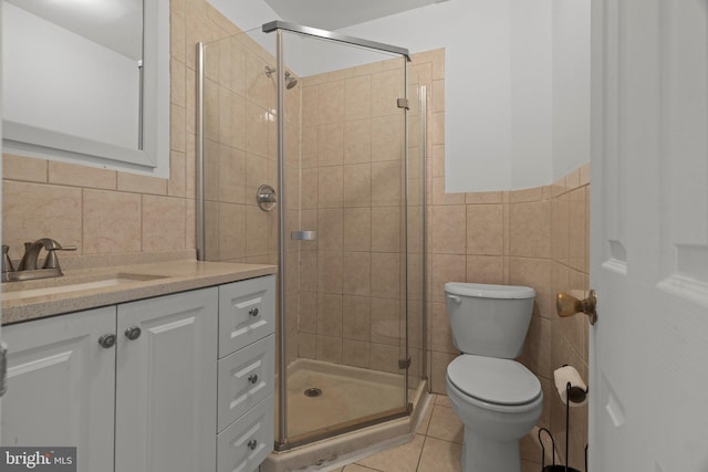 bathroom with vanity, tile patterned flooring, toilet, tile walls, and an enclosed shower