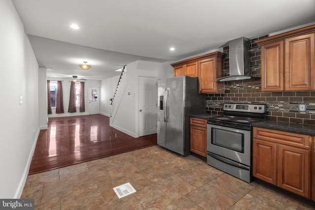 kitchen featuring decorative backsplash, wall chimney exhaust hood, stainless steel appliances, ceiling fan, and wood-type flooring