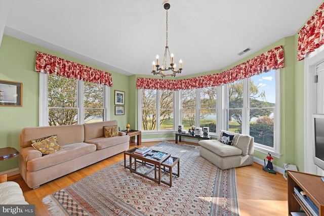 7369 Drum Point Rd, Saint Michaels, MD 21663 - living area with healthy amount of natural light, a chandelier, wood finished floors, and baseboards