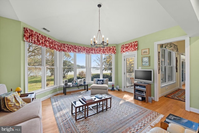 living room with an inviting chandelier and light wood-type flooring