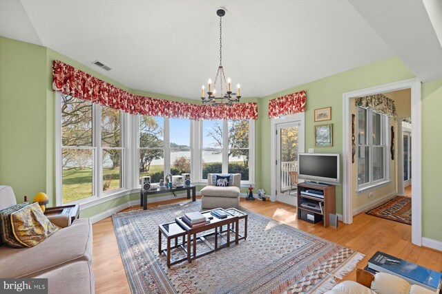 7369 Drum Point Rd, Saint Michaels, MD 21663 - living area with a chandelier, baseboards, and light wood finished floors