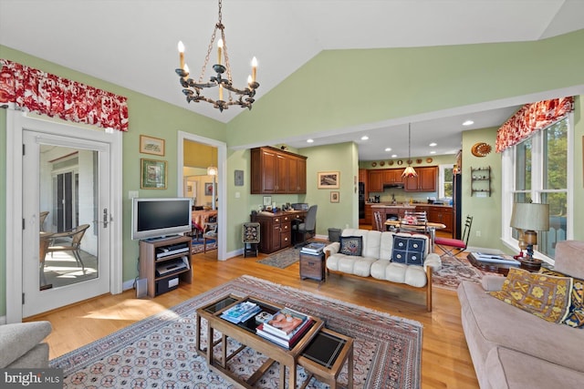 living room featuring a chandelier, light hardwood / wood-style floors, and vaulted ceiling