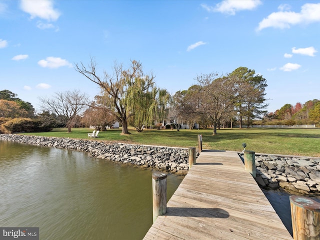 view of dock featuring a yard and a water view