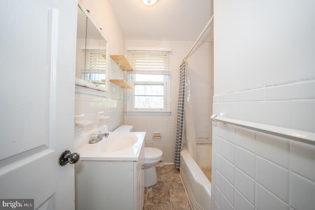 full bathroom featuring shower / bath combo with shower curtain, vanity, tile walls, and toilet