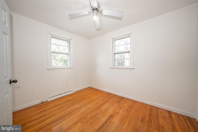 empty room featuring ceiling fan, a healthy amount of sunlight, and wood-type flooring