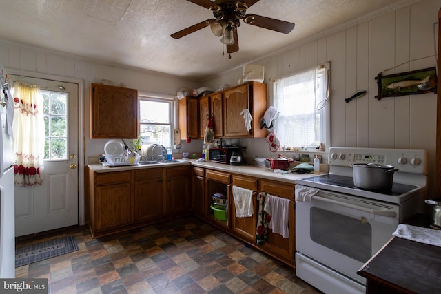 kitchen featuring a textured ceiling, white electric stove, ceiling fan, and ornamental molding