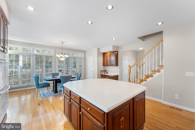 kitchen with pendant lighting, a center island, a healthy amount of sunlight, and light wood-type flooring