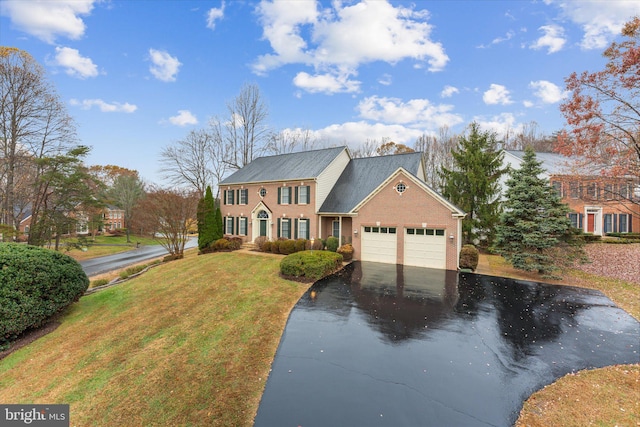 colonial home featuring a garage and a front yard