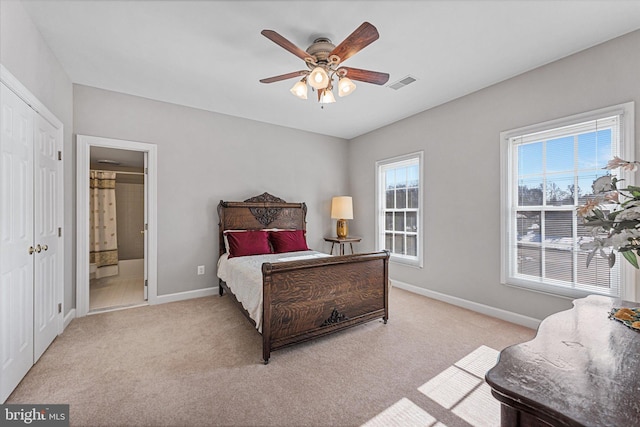 carpeted bedroom with ceiling fan and ensuite bath