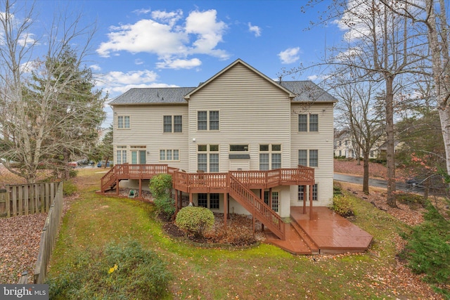 rear view of house featuring a deck and a lawn