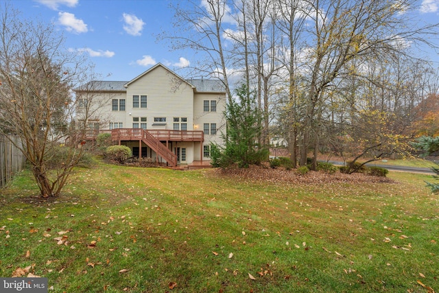 back of property featuring a wooden deck and a yard