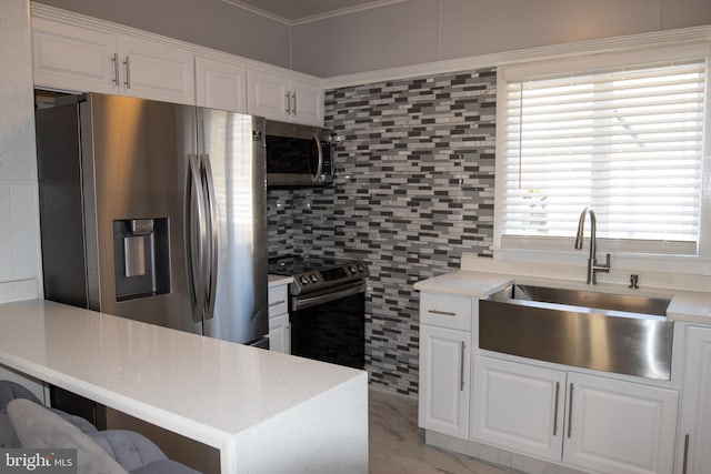 kitchen featuring sink, backsplash, kitchen peninsula, white cabinets, and appliances with stainless steel finishes