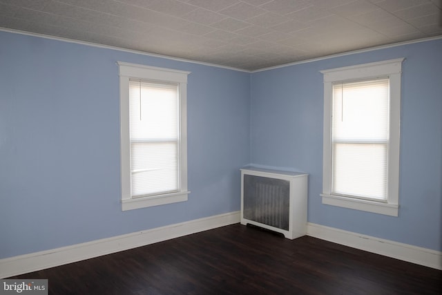 unfurnished room with radiator heating unit, crown molding, and dark wood-type flooring