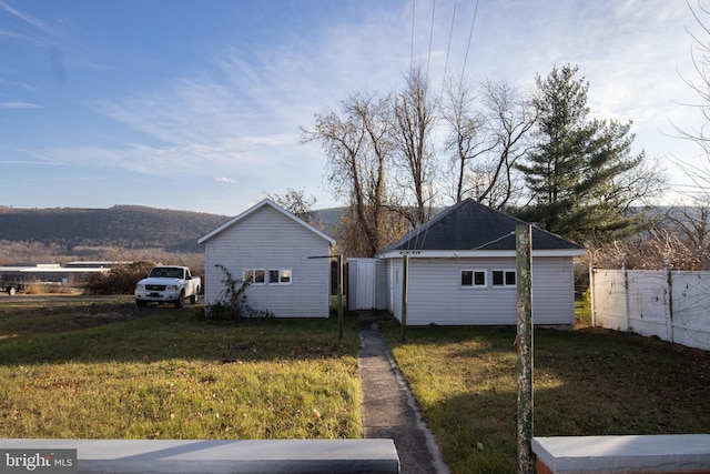 view of property exterior with a mountain view and a lawn